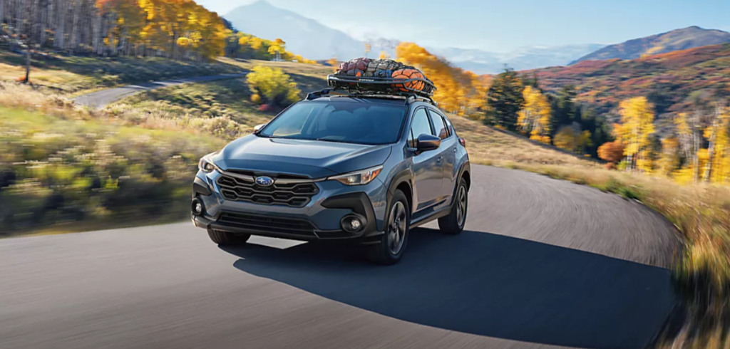 A new blue 2024 Subaru Crosstrek on the road.