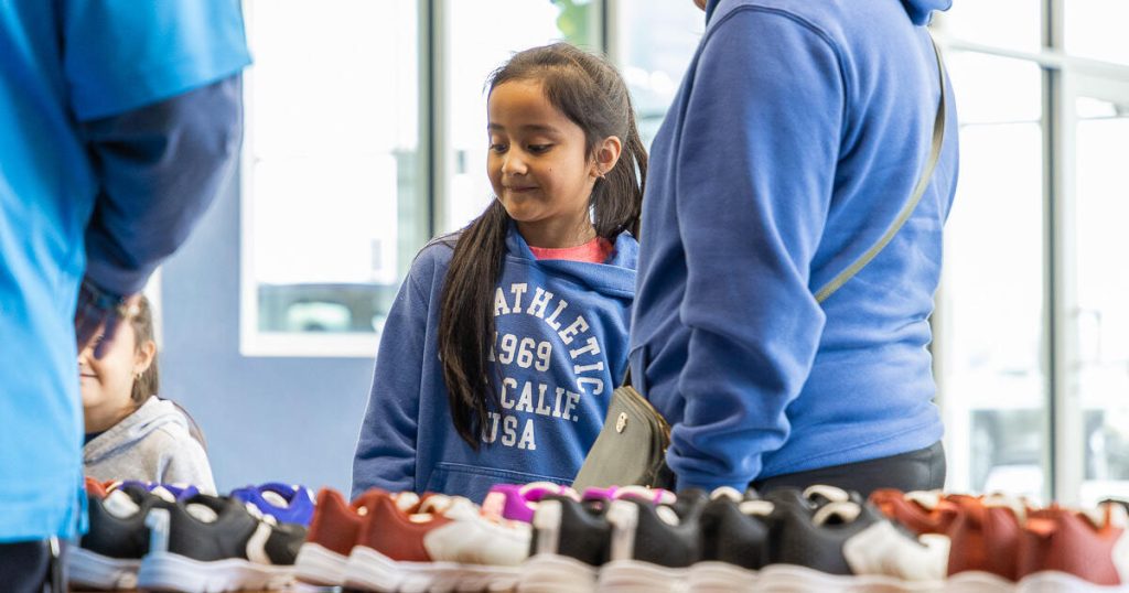 A young girl looks at rows of shoes at Wyatt Johnson Subaru's dealership shoe drive to give away 200+ shoes to children in need in Clarksville, TN.