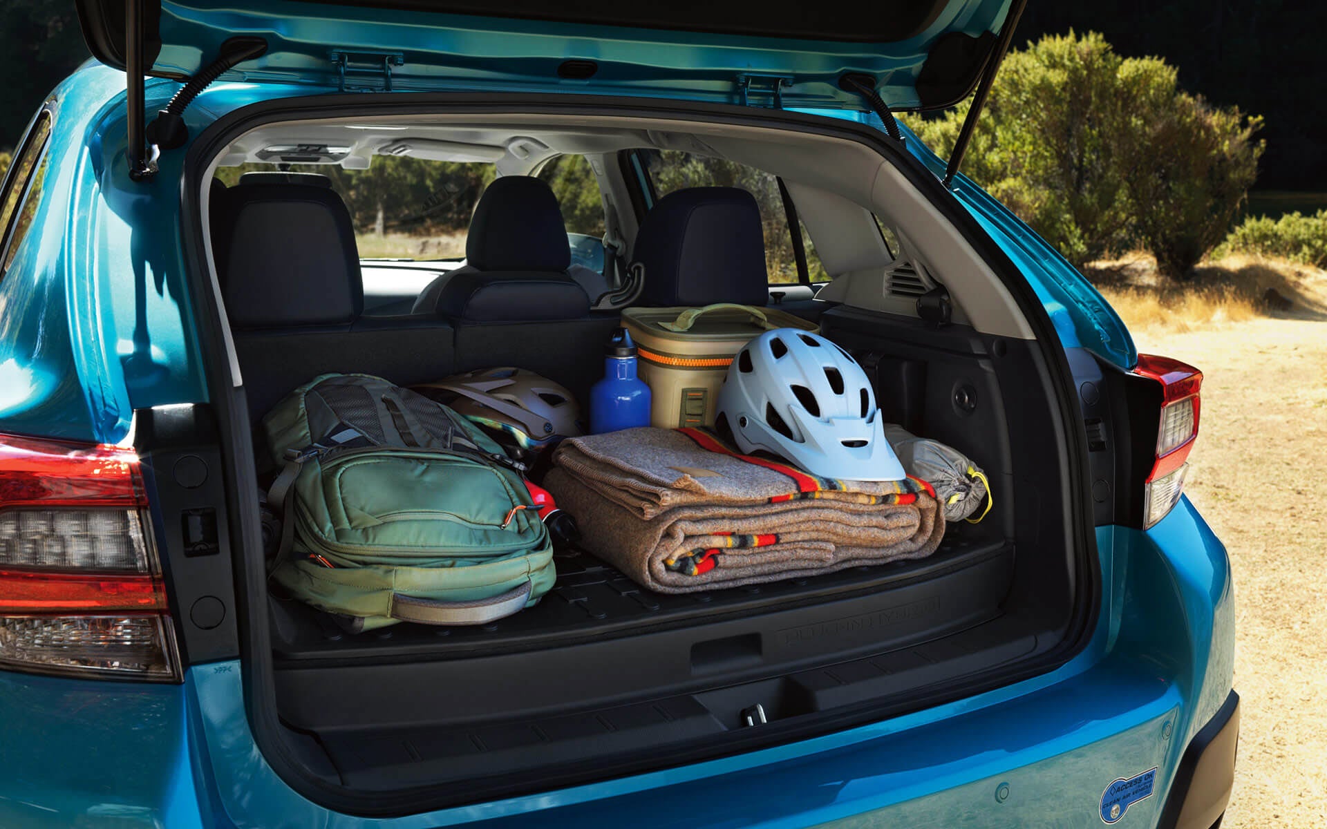 A backpack, blanket, and bike helmet in the rear cargo area of a Crosstrek Hybrid | Wyatt Johnson Subaru in Clarksville TN
