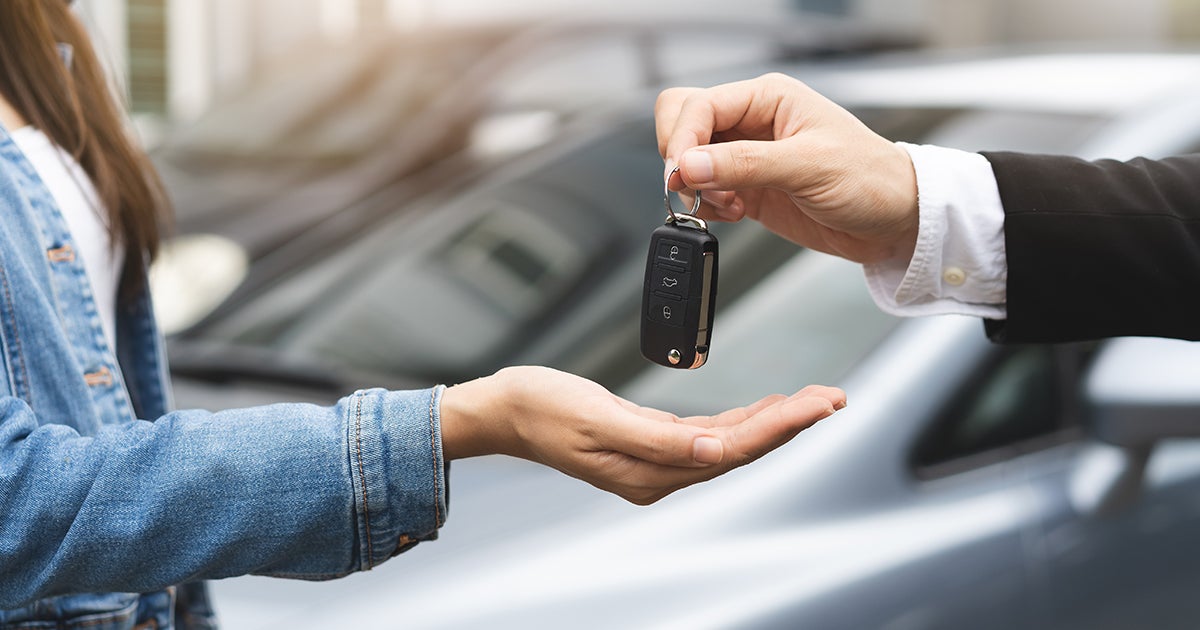 Sales member giving a customer keys 